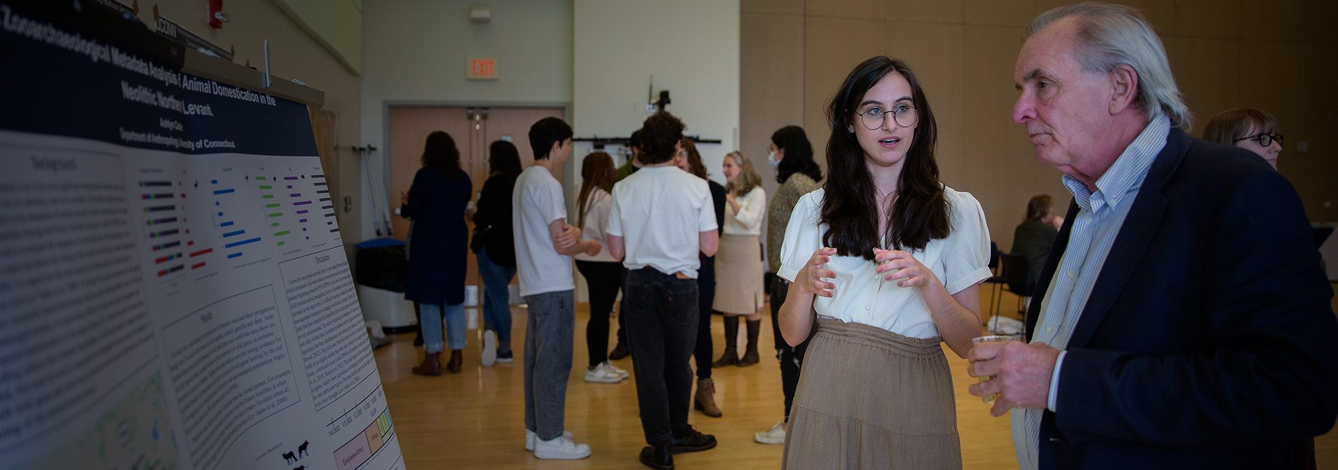 A student discusses her research presentation with a professor.
